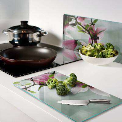 Glass kitchen board Magnolia flowers against a background of greenery