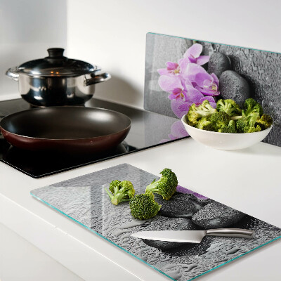 Glass chopping board Flowers and stones against the water