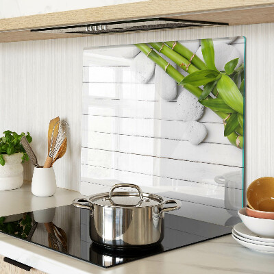 Glass kitchen board Bamboo and stones on a wood background