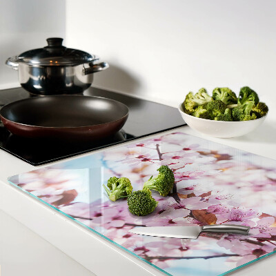 Glass kitchen board Cherry blossoms on a blue background