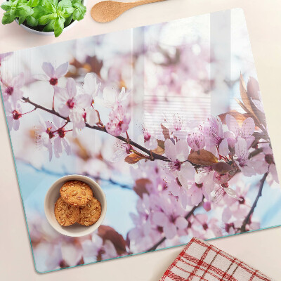 Glass kitchen board Cherry blossoms on a blue background
