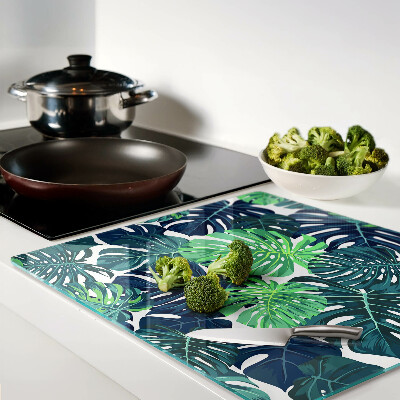 Glass kitchen board Monstera leaves on a tropical background