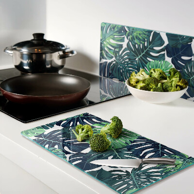 Glass kitchen board Monstera leaves on a tropical background