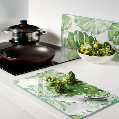 Glass kitchen board Monstera leaves on a light background