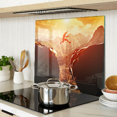 Glass kitchen board Jumping in the mountains at sunset