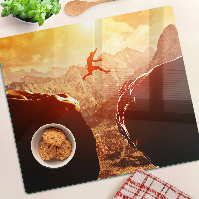Glass kitchen board Jumping in the mountains at sunset