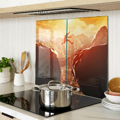 Glass kitchen board Jumping in the mountains at sunset