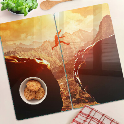 Glass kitchen board Jumping in the mountains at sunset