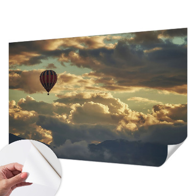 Nursery wall mural with a balloon floating among the clouds