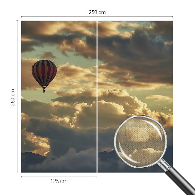 Nursery wall mural with a balloon floating among the clouds