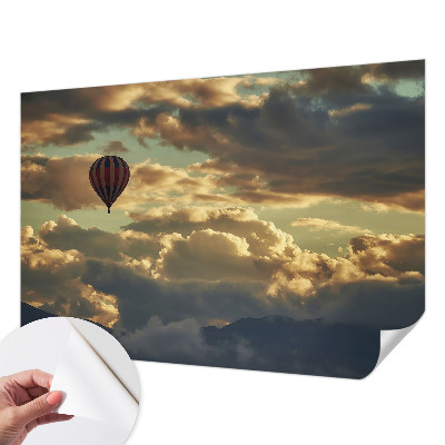 Nursery wall mural with a balloon floating among the clouds