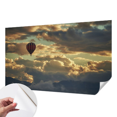 Nursery wall mural with a balloon floating among the clouds