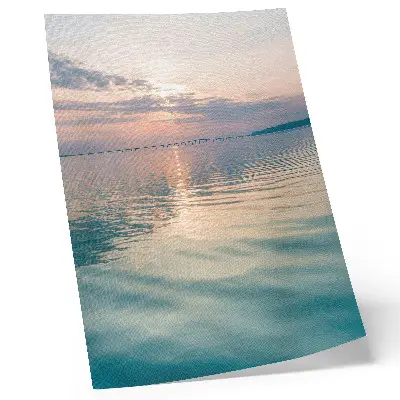 Poster calm water surface with a bridge reflecting warm sky colors