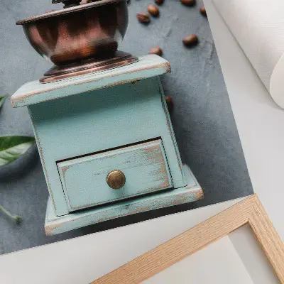 Decorative poster old turquoise coffee grinder with coffee beans and green leaves