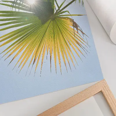 Poster palm leaves on a blue background in the sunlight