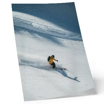 Poster skier in a yellow jacket on a snowy slope with a shadow