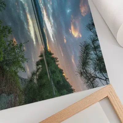 Decorative canvas print featuring a calm lake with green trees and sky reflections