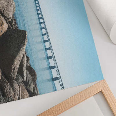Decorative canvas print Bridge over blue water stones on the shore