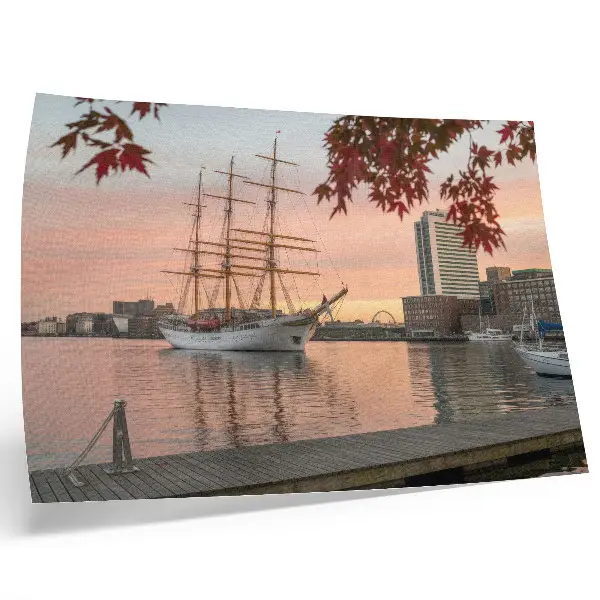 Decorative canvas print Sailing ship at sunset with a peaceful cityscape panorama