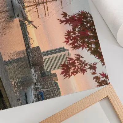 Decorative canvas print Sailing ship at sunset with a peaceful cityscape panorama