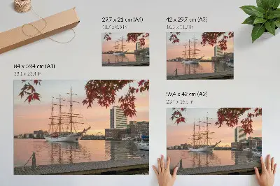 Decorative canvas print Sailing ship at sunset with a peaceful cityscape panorama