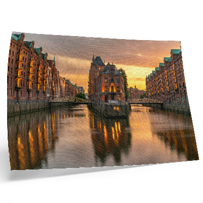 Decorative canvas print Calm water, brick buildings, warm light