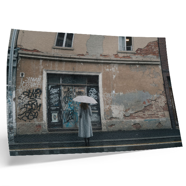Decorative canvas print A person with an umbrella in front of a wall full of graffiti