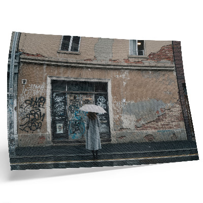 Decorative canvas print A person with an umbrella in front of a wall full of graffiti
