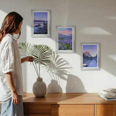 Framed triptych mountain landscapes featuring water, sky, and a field of flowers