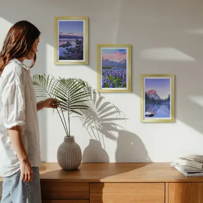 Framed triptych mountain landscapes featuring water, sky, and a field of flowers
