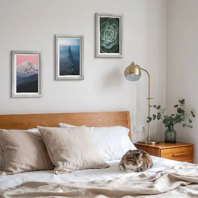 Framed triptych mountains with a pink sky, water, and green succulents
