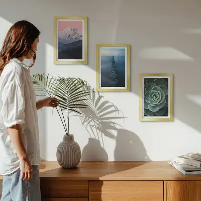 Framed triptych mountains with a pink sky, water, and green succulents