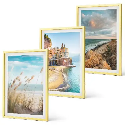 Set of 3 framed wall art pieces featuring landscape scenes of beaches cliffs and cities