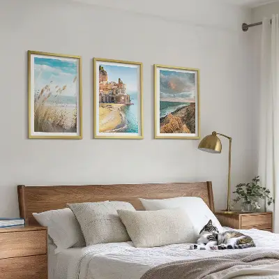 Set of 3 framed wall art pieces featuring landscape scenes of beaches cliffs and cities