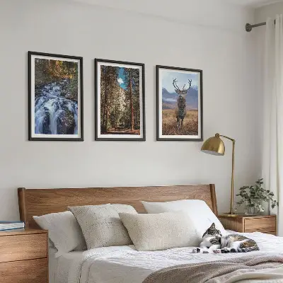 Three-piece wall art set featuring a waterfall in a mountain forest with deer and nature scenery
