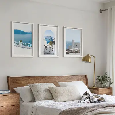 Set of 3 framed wall art pieces featuring white buildings by the sea in Greece